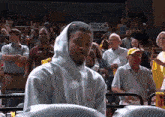a man wearing a hooded sweatshirt stands in front of a sign that says focus execute
