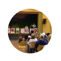 a group of people sitting in chairs in front of a stage with a sign that says ' tfp ' on it