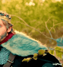 a man with a crown on his head and a fur coat