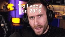 a man wearing headphones is talking into a microphone with the words troll vocal en 2015 above him