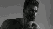 a black and white photo of a shirtless man with his arm up .