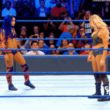 two women in a wrestling ring with one wearing a shirt that says ' the man '