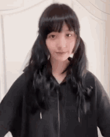 a young girl with pigtails is wearing a black hoodie .