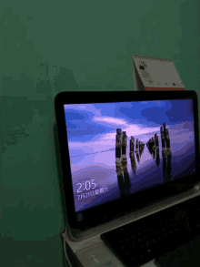 a laptop screen shows the time as 2:05 on 7/21