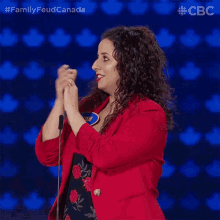 a woman in a red jacket is clapping her hands
