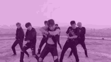 a group of young men are dancing on top of a rooftop .