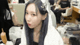 a woman with purple hair is wearing a white veil and earrings