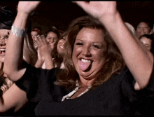 a woman sticking her tongue out at a crowd of people