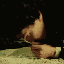 a man is laying on a carpet sniffing a piece of cocaine .