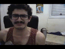 a man with glasses and a mustache looks at the camera