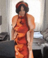 a woman in a hot dog costume stands in front of a laptop computer