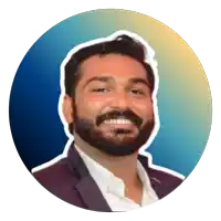 a man with a beard is smiling and wearing a suit