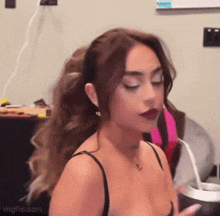a woman in a black bra is drinking from a cup