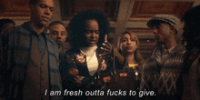 a group of people are standing in a room and one of them is talking .