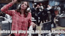 a woman wearing headphones is dancing in an office while a group of people are fighting in the background .