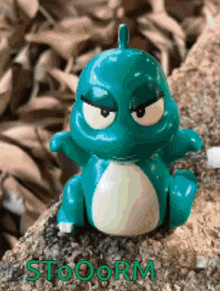 a toy dinosaur is sitting on a rock with the word stooorm written on the bottom