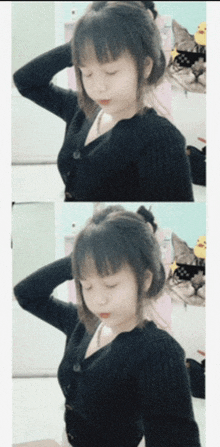 a girl in a black sweater has her hands on her head