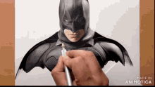a person is drawing a picture of batman with a marker