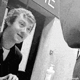 a black and white photo of a man in front of a sign that says ' tc '