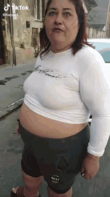 a woman wearing a white crop top and black shorts with the word best on the thigh