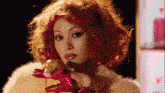 a woman with red hair is holding a stuffed animal in her hands