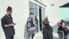 a group of people are standing in front of a building and talking to each other .