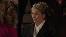 a woman in a suit and white shirt is laughing