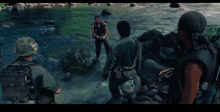 a group of soldiers are standing in a river with a man standing in the middle