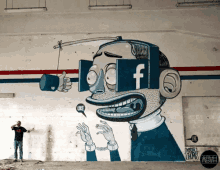 a man stands in front of a mural of a man with a facebook logo on his face