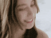 a woman without a shirt is smiling with her eyes closed .