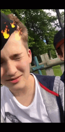 a young man with a hat with flames on his head