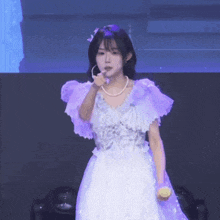a girl in a purple dress is holding a lemon in her hand .