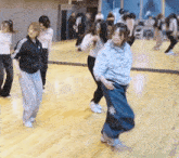 a group of women are dancing in front of a large mirror