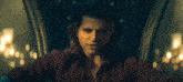 a man in a red shirt is sitting in a blue chair in a dark room .