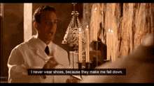 a man in a white lab coat says i never wear shoes because they make me fall down in front of candles