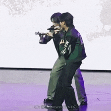 two men standing on a stage with one wearing a green jacket that says martin