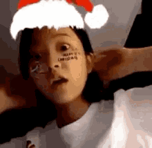 a young girl wearing a santa hat and glasses .
