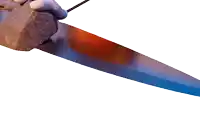 a person is holding a large rock with a knife in their hand
