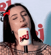 a woman holding a microphone with the letters ari on it
