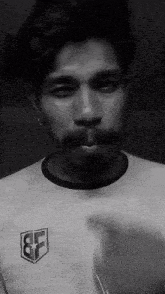 a man with a mustache is wearing a white shirt that says bf