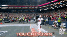 a football player is running on the field with the words touchdown written on the bottom .