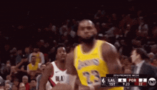 a basketball player wearing a yellow jersey with the number 23 on it is running on the court .