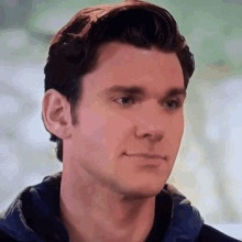a close up of a man 's face with a hoodie on