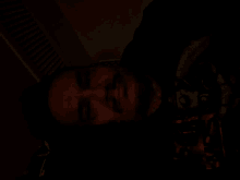 a man with a beard is smiling in a dark room
