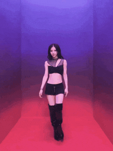 a woman in a black crop top and shorts is dancing