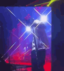 a man in a white shirt is standing on a stage in front of a screen .