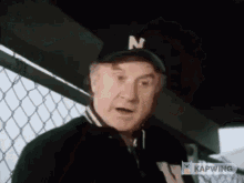 an older man wearing a black hat with the letter n on it