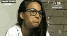 a woman wearing glasses making a funny face .