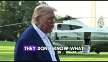 donald trump stands in front of a united helicopter