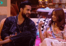 a man and a woman are sitting on a couch .